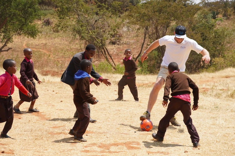 Vorstandsvorsitzender Timo Holub beim Fußballspielen mit tansanischen Kindern